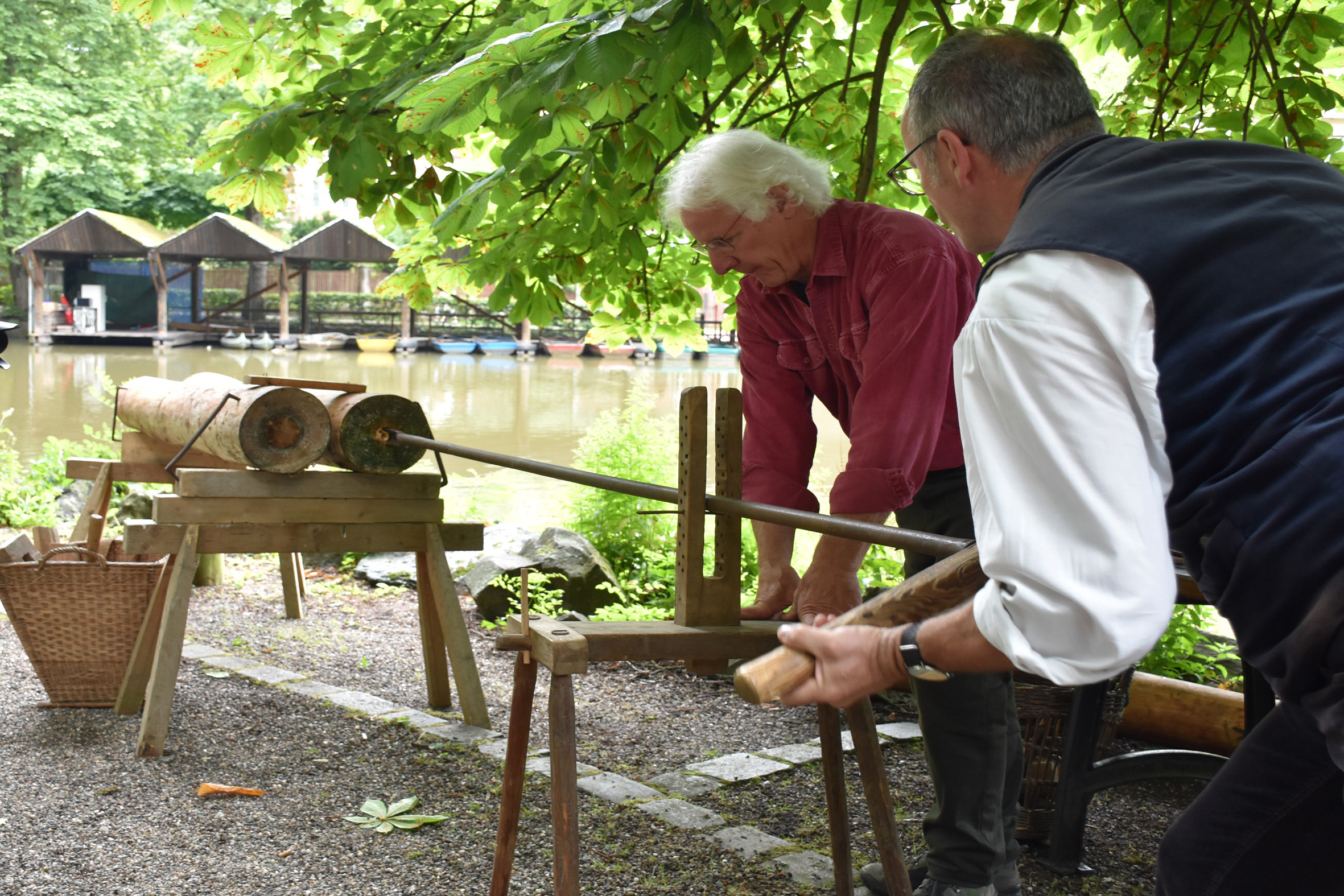 Zwei Männer arbeiten an einem Holzbock.