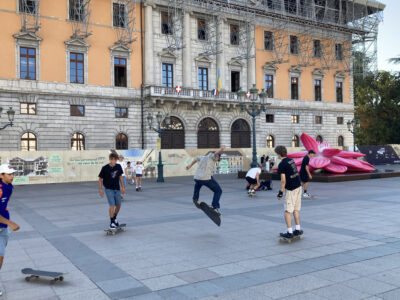 Junge Skater auf dem Platz vor einem historischen Gebäude.