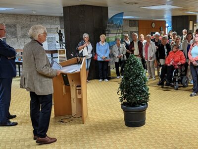 Im Foyer des Rathauses stehen mehrere Menschen nebeneinander
