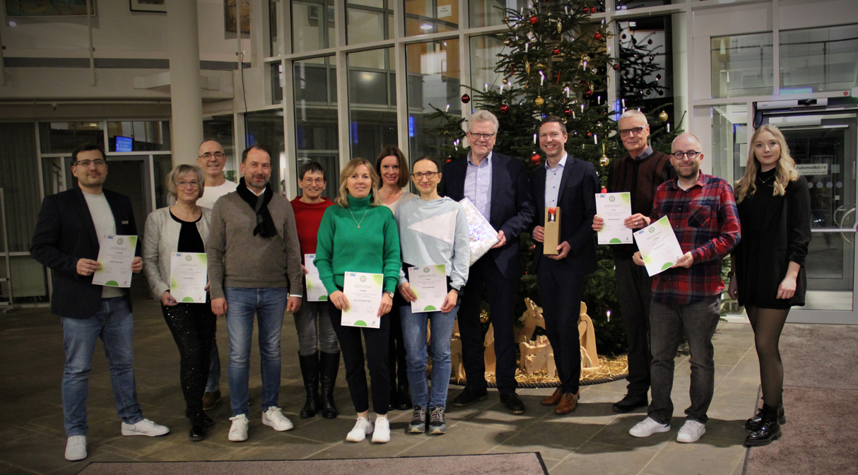 Eine Menschengruppe vor einem großen Weihnachtsbaum im Eingangsbereich des Landratsamtes Bayreuth. | Foto: Landratsamt Bayreuth