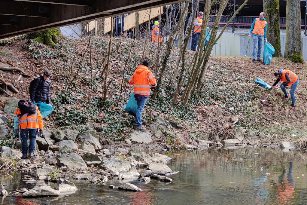 Menschen sammeln Müll am Ufer eines Flusses. | Foto: Christina Fehmel