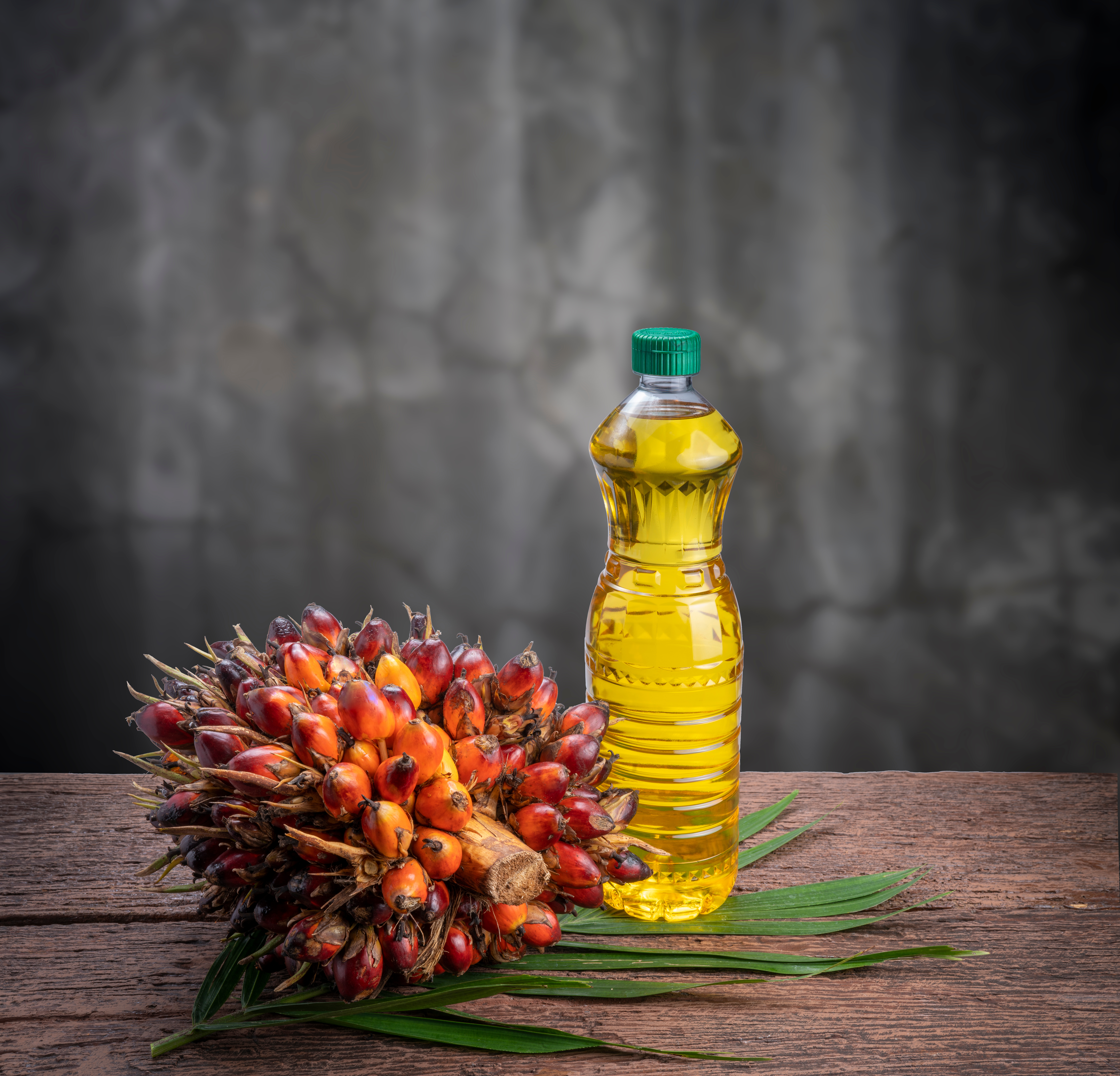 Eine Flasche Palmöl mit Ölfrüchten
