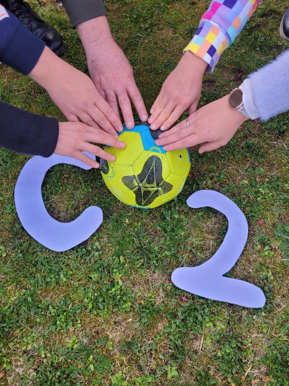 Fünf Hände greifen nach einem Logo