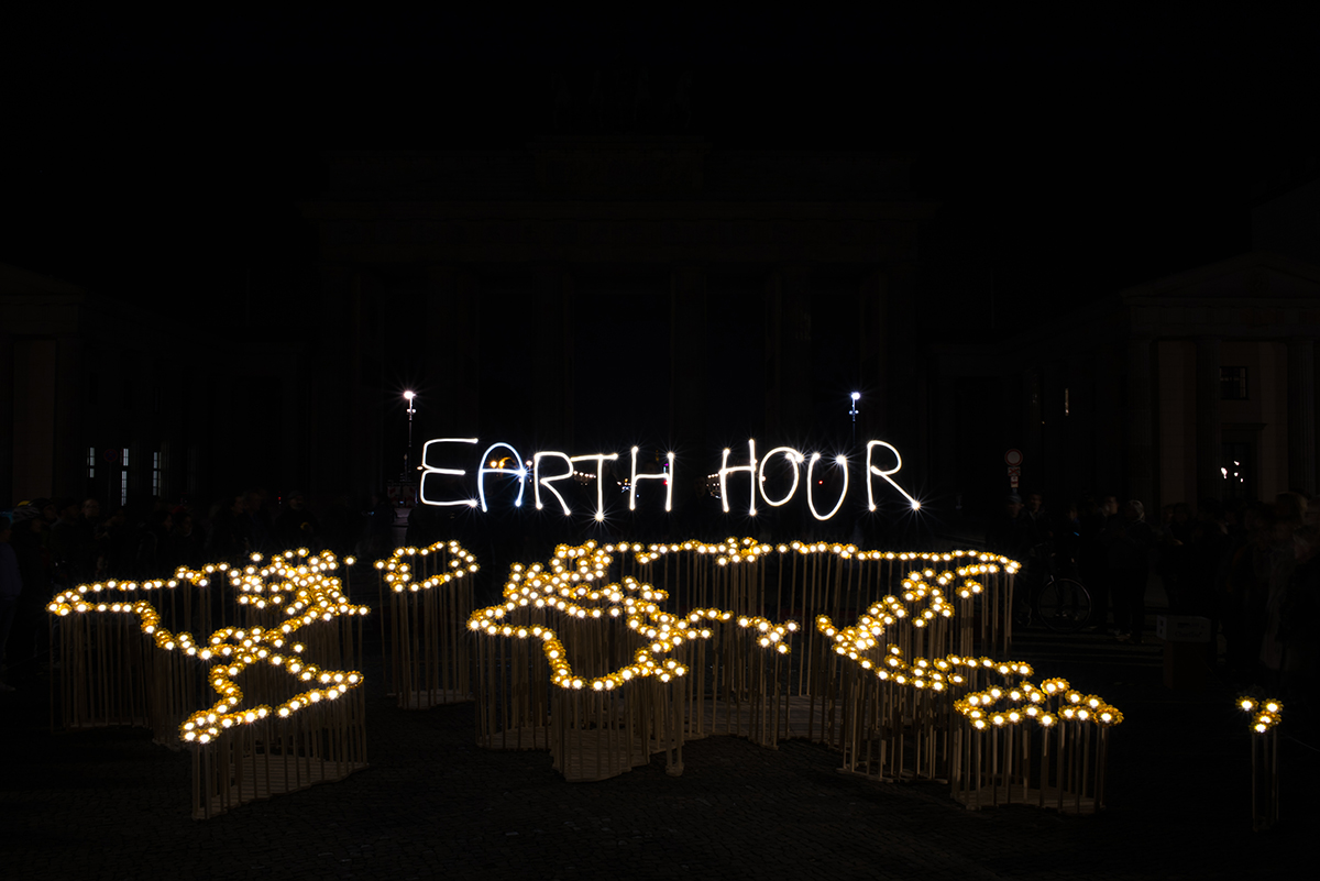 Schwarzer Hintergrund, einzelne Lichter zeichnen die Erde nach und das Wort Earth Hour