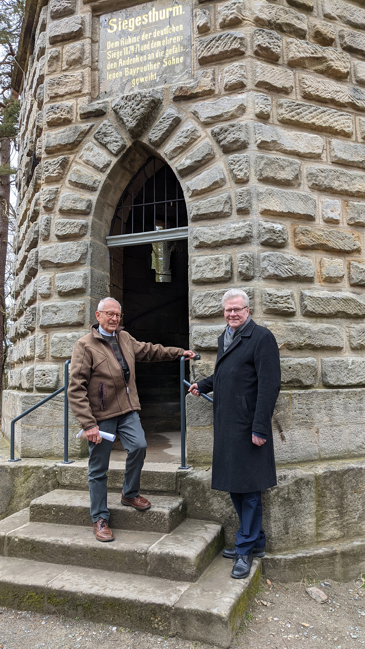 Reinhold Dumproff und Oberbürgermeister Thomas Ebersberger stehen vor dem Eingang des Siegesturmes.