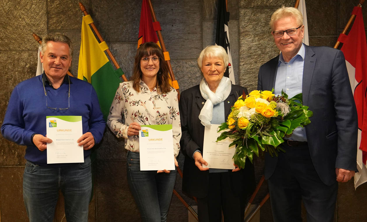 Zwei Männer und zwei Frauen halten Urkunden in den Händen.