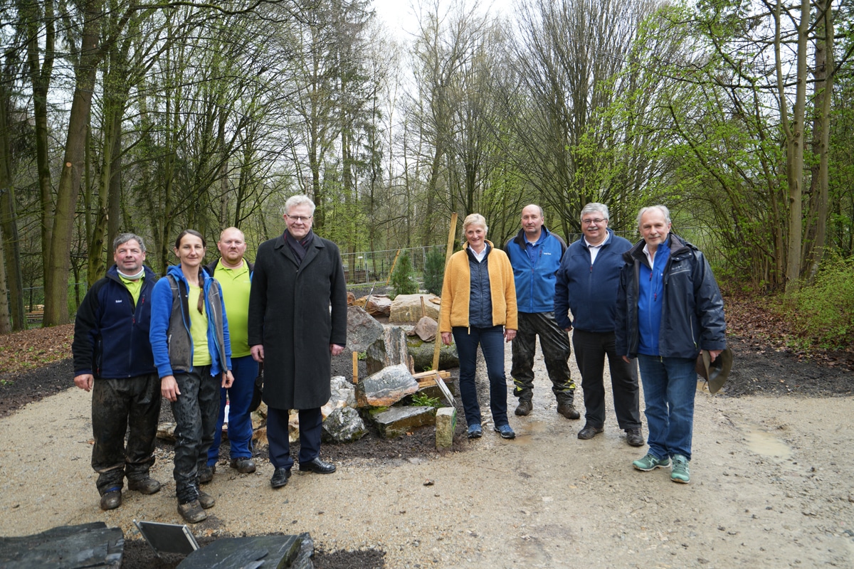 Eine Gruppe Frauen und Männer steht auf einer Gartenbaustelle.