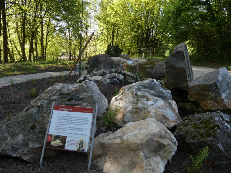 Ein Hinweisschild steht vor einem Stein