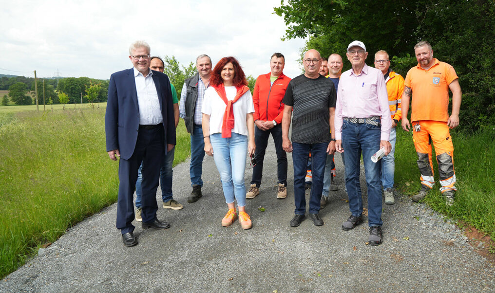 Eine Gruppe von Menschen steht auf einem Wirtschaftsweg