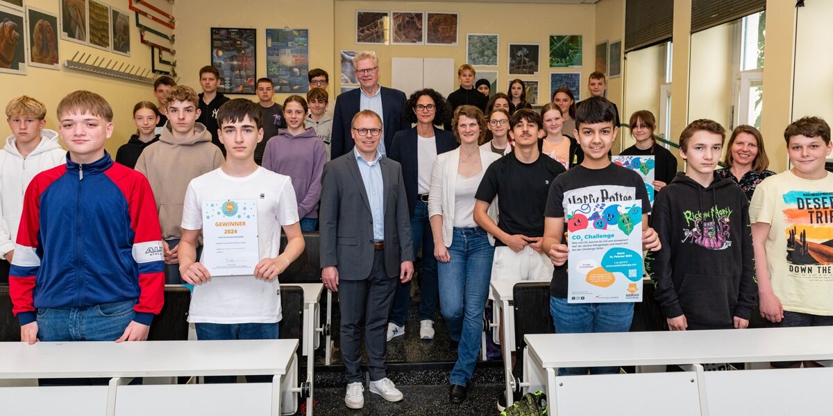 Schülerinnen und Schüler der 8c des Graf-Münster-Gymnasiums und ihre Lehrerin Tabea Tchokothe (2. Reihe re.) lassen sich für ihren Gewinn der CO2-Schulchallenge der Europäischen Metropolregion Nürnberg in der Kategorie „Kreativstes und innovativstes Portfolio“ feiern. Es gratulierten (im Mittelgang von hinten): Oberbürgermeister Thomas Ebersberger, Schulpflegerin Luisa Barjak-Funke, Klimaschutzmanagerin Gesa Thomas und Schuldirektor Christian Kramer.