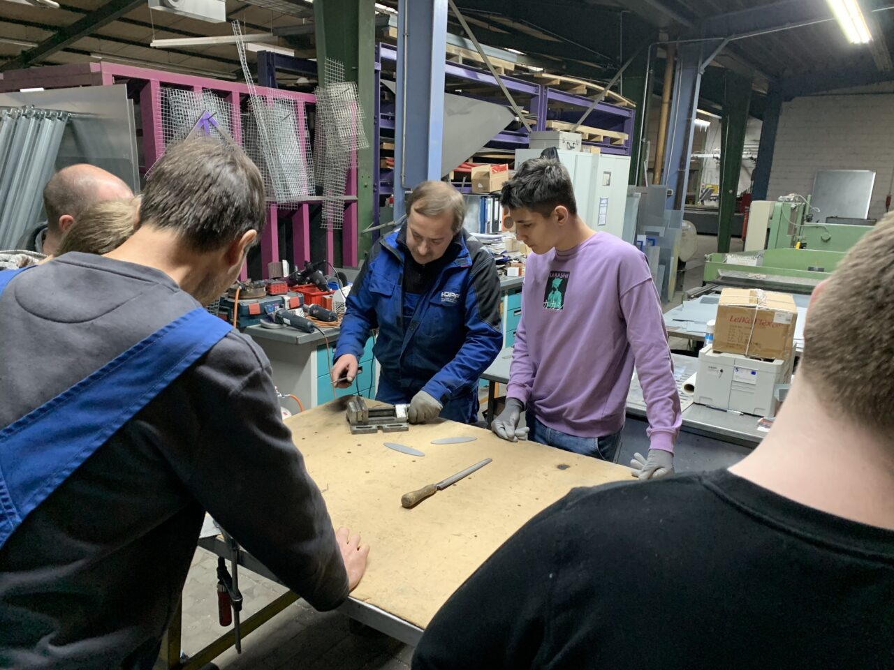 Jugendliche bei der Metallbearbeitung in einer Werkstatt.