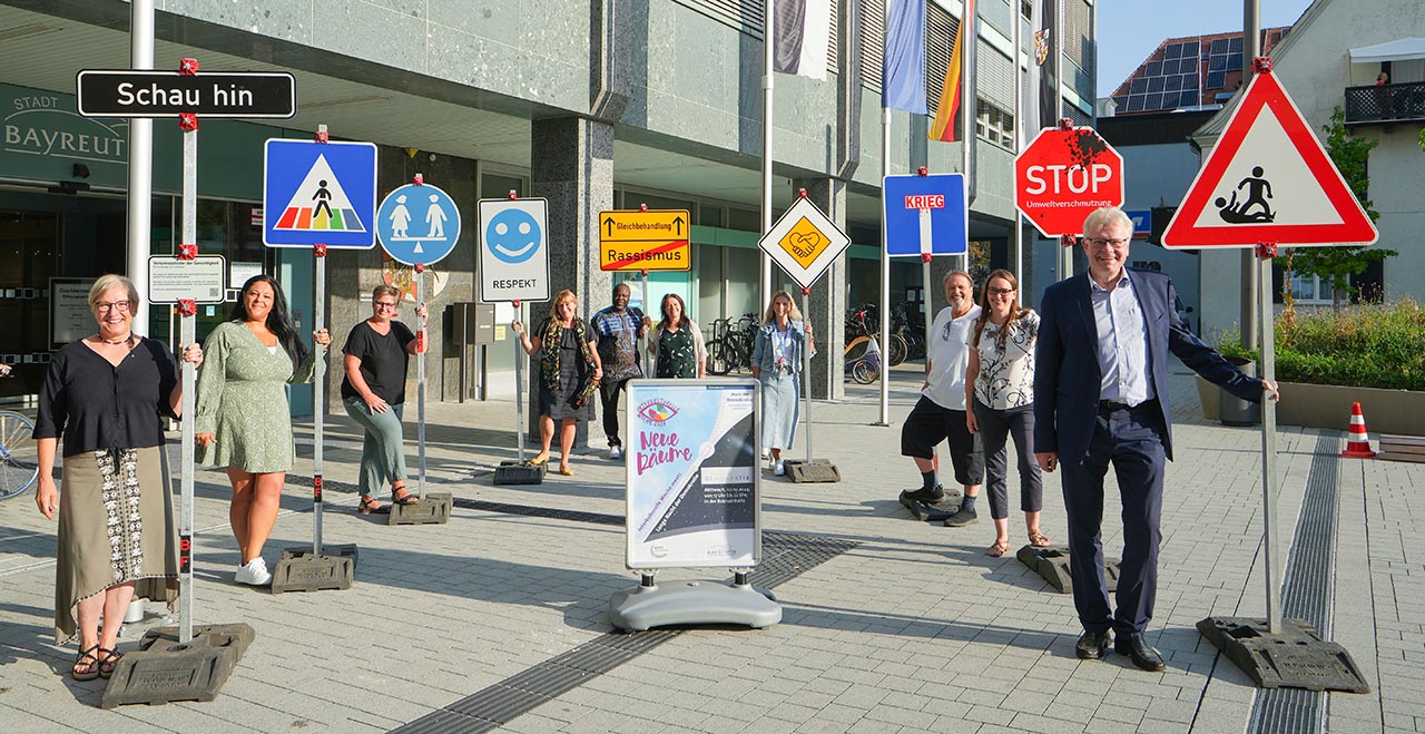 Menschen stehen vor den Verkehrsschildern der IKW 2024