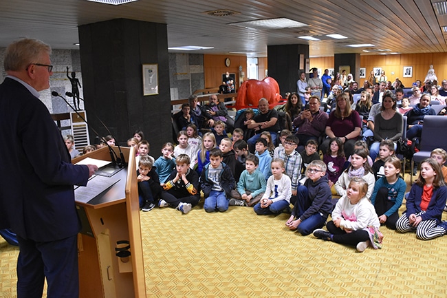 Die Kinder sitzen auf dem Boden vor dem Oberbürgermeister