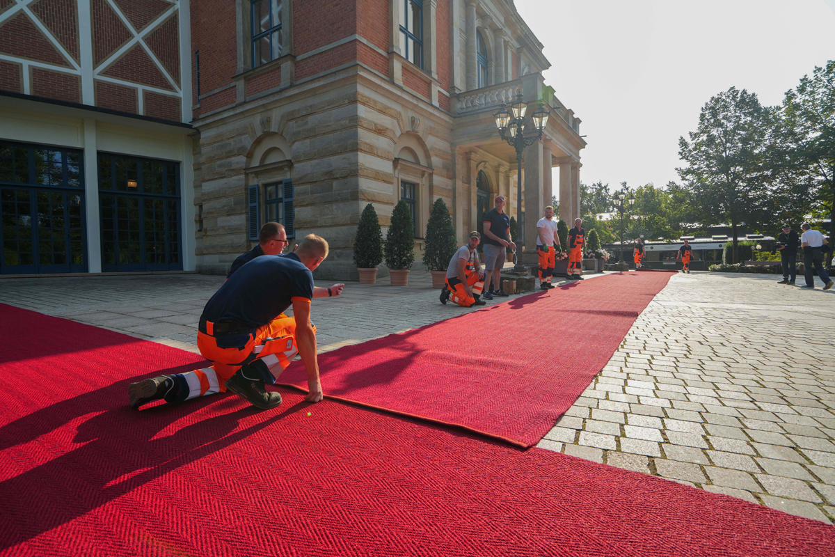 Aufbau des Roten Teppichs vor dem Festspielhaus am Tag der Eröffnung der Festspiele.