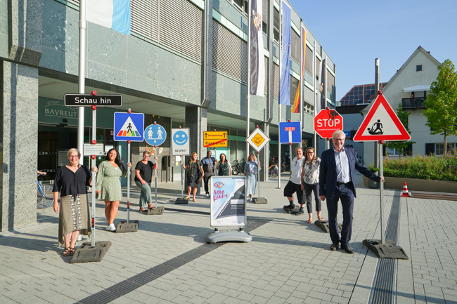 Ein Gruppe Personen steht mit symbolischen Schildern vor dem Neuen Rathaus. Foto: Stadt Bayreuth