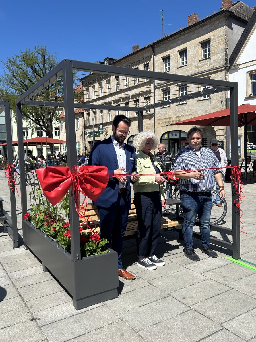 BGM A. Zippel, Baureferentin U. Kelm und B. Spindler (Amt für Städtebauföerderung) stehn in einem der mobilen "Grünen Wohnzimmern" und schneiden ein Band durch, im Hintergund das Stadtparkett