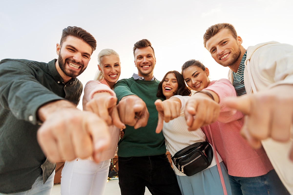 Menschengruppe, die mit den Finger auf den Betrachter zeigt