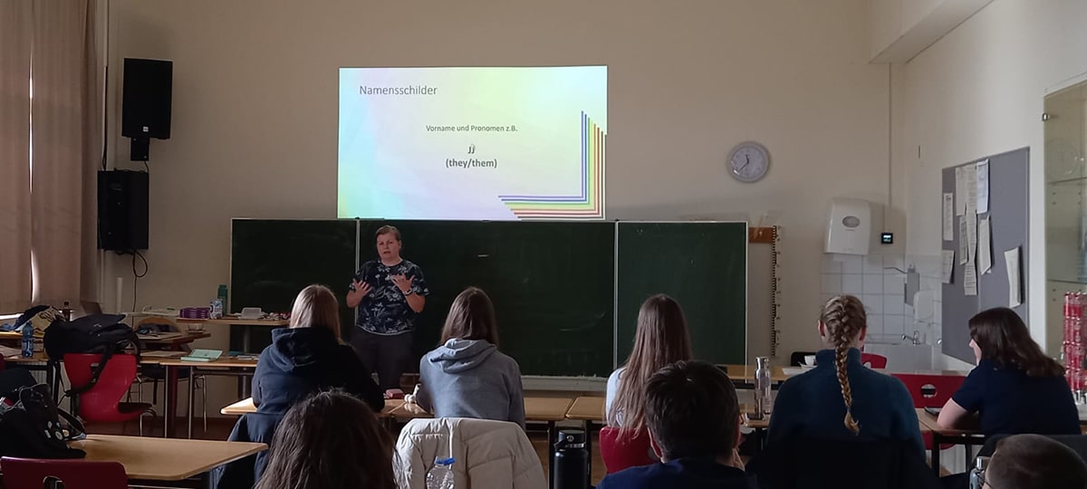 Schüler sitzen mit dem Rücken zum Fotografen und schauen an die Tafel