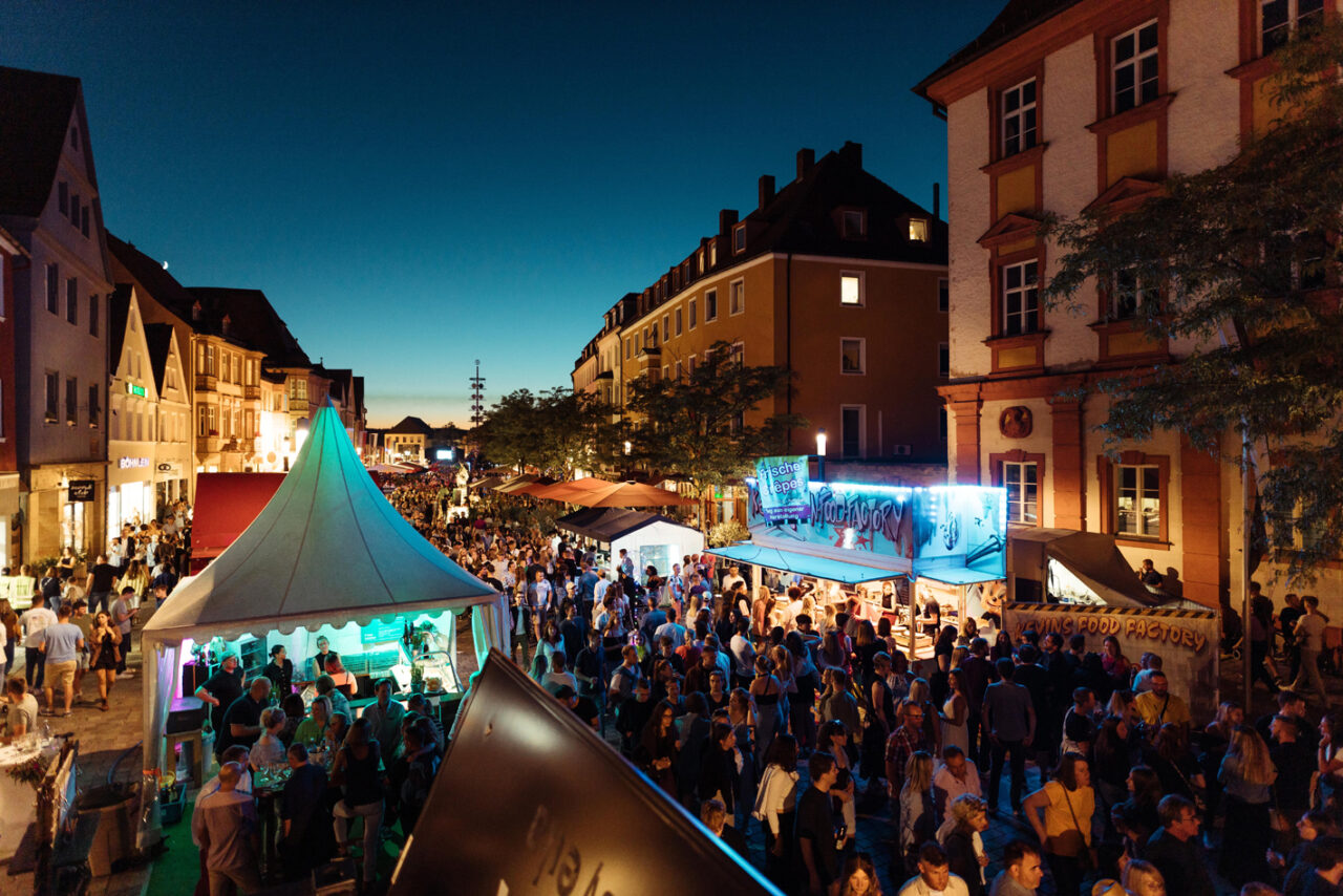 Eine Gasse voller Menschen am Abend. | Foto: BMTG