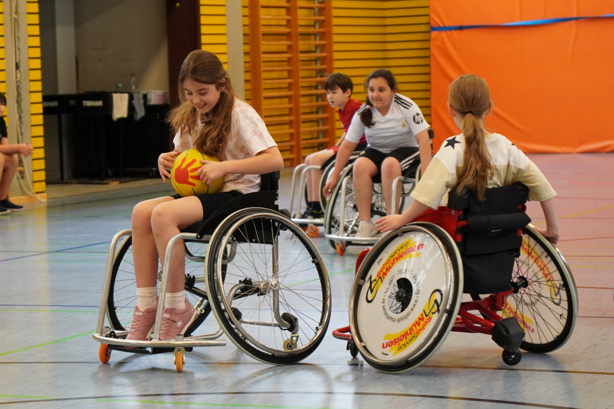 Schülerinnen und Schüler spielen Rollstuhlbasketball