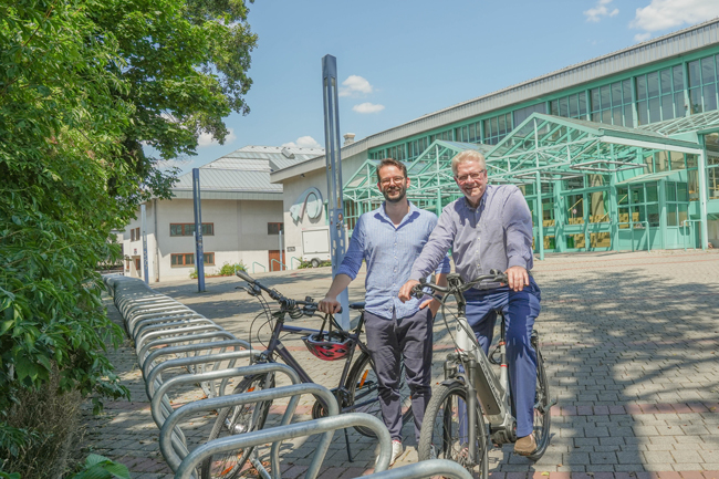 Oberbürgermeister Thomas Ebersberger und Zweiter Bürgermeister Dr. Andreas Zippel freuen sich über die neuen Fahrradabstellanlagen vor der Oberfrankenhalle beziehungsweise dem Sportzentrum. Damit können Besucherinnen und Besucher von Veranstaltungen ihre Drahtesel sicher abstellen. Foto: Stadt Bayreuth