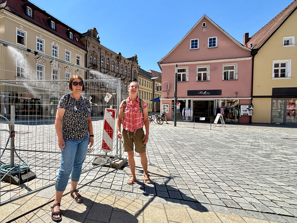 Die Stadt Bayreuth hat in der Fußgängerzone unter anderem beim Caffé Rossi und hier beim Ehrenhof Sprühnebelschläuche zur Abkühlung aufstellen lassen, sehr zur Freude unter anderem dieser beiden Passantinnen. Foto: Stadt Bayreuth
