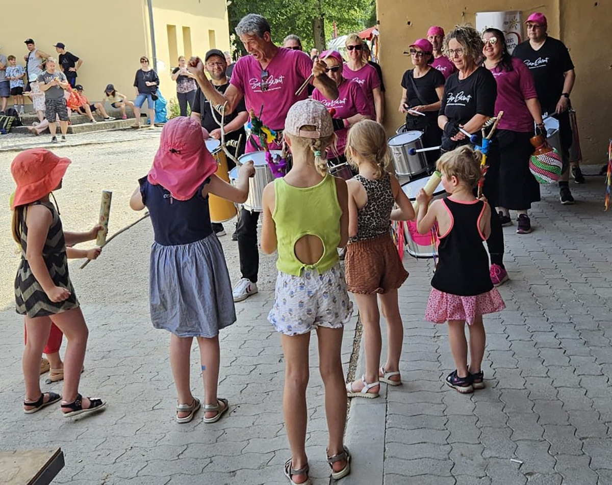 Eine Gruppe Menschen tanzt und musiziert gemeinsam.