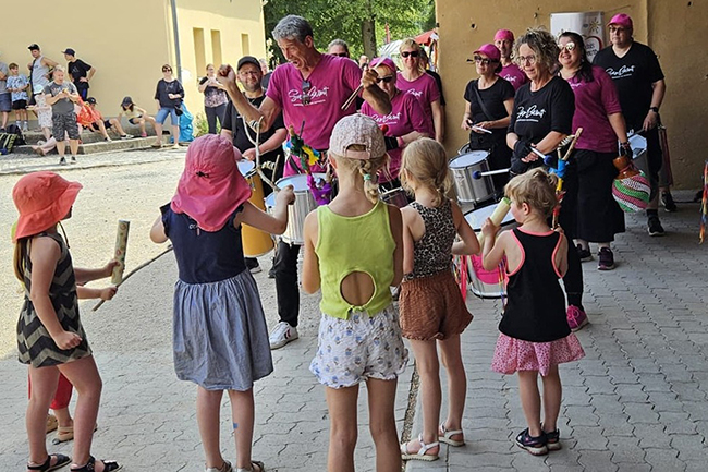 Eine Gruppe Menschen tanzt und musiziert gemeinsam.