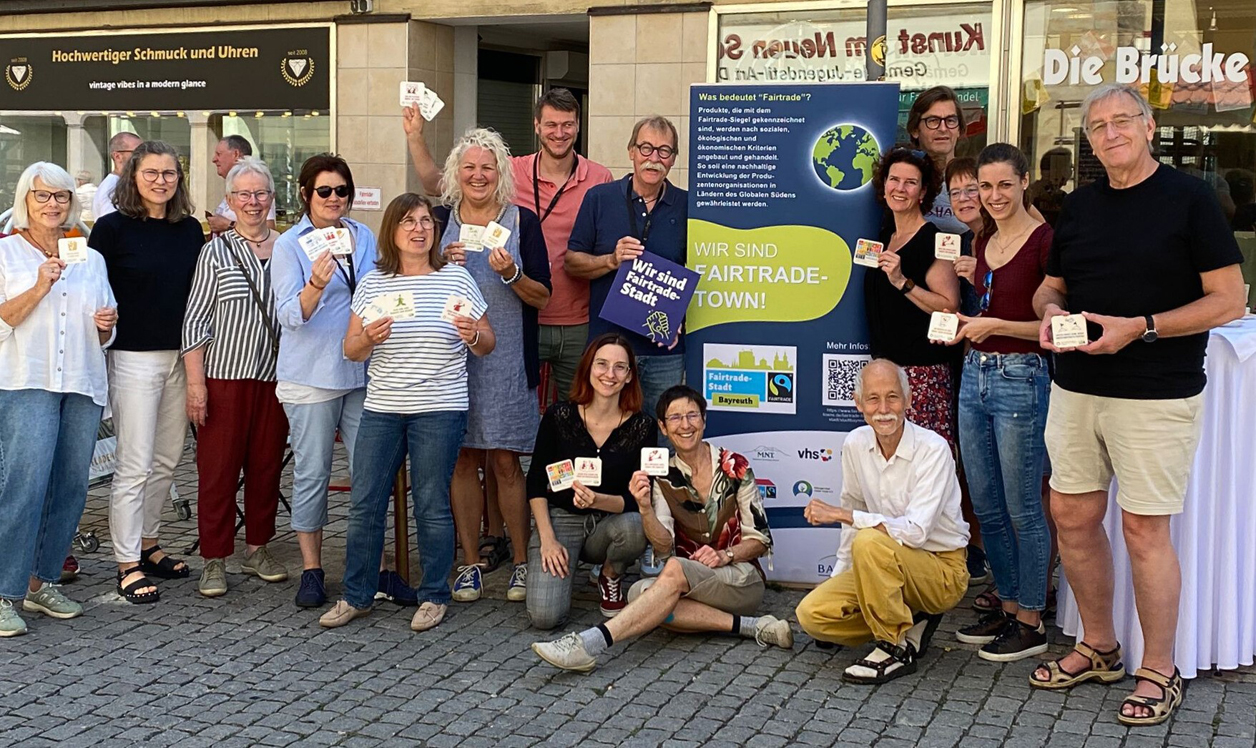 Zahlreiche Personen stehen und sitzen vor einem Geschäft und halten Bierdeckel in den Händen. | Foto: Stadt Bayreuth