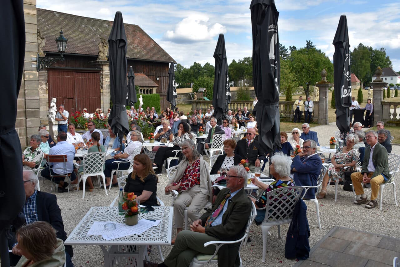 Zahlreiche Personen sitzen an Tischen in einem Barockgarten. | Foto: Andreas Türk