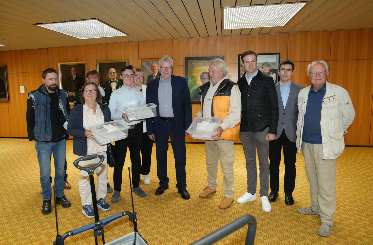 Eine Gruppe von Personen steht mit Unterschriftenlisten im Rathaus-Foyer. | Foto: Stadt Bayreuth
