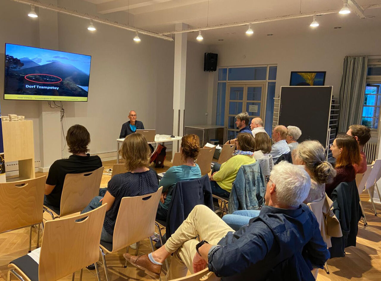 Ein Mann referiert vor mehreren Zuhörern, die auf Holzstühlen sitzen. | Foto: Fair-Trade-Town Bayreuth