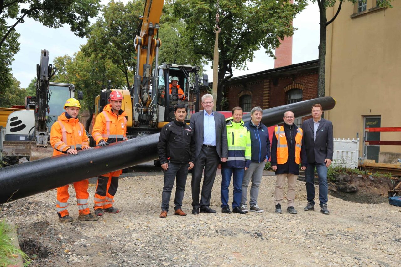 Mehrere Personen stehen auf einer Baustelle neben einem Leitungsrohr. | Foto: Stadtwerke Bayreuth
