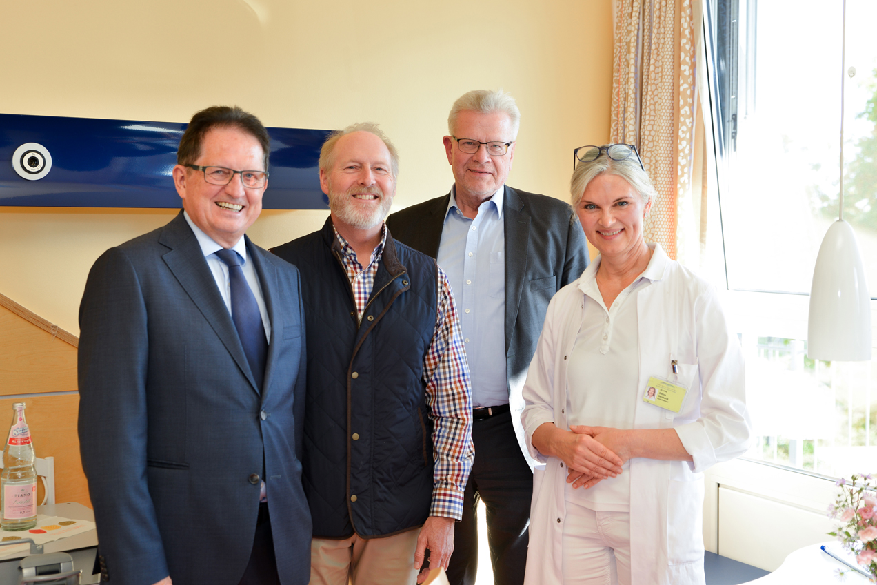 Drei Männer und eine Ärztin stehen in einem Behandlungszimmer. | Foto: Klinikum Bayreuth GmbH