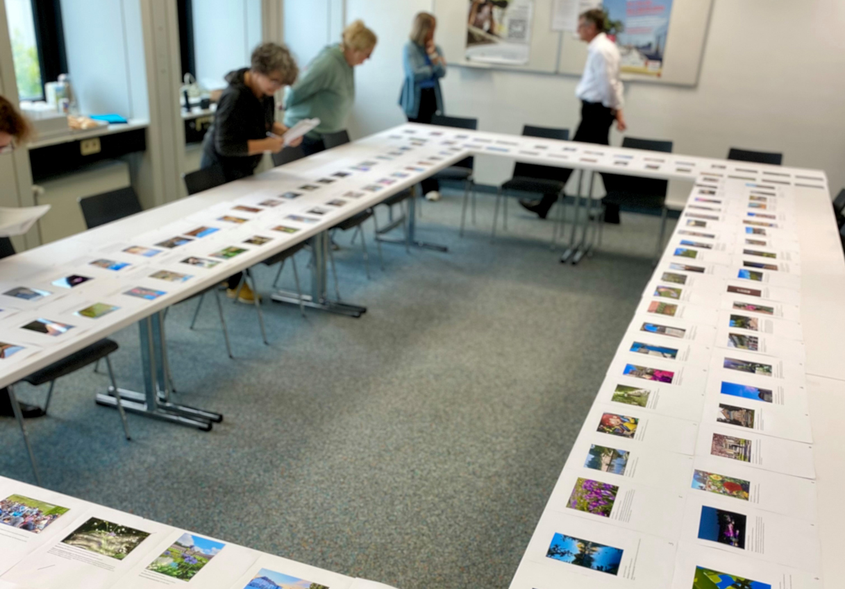 Mehrere Personen begutachten Fotos, die auf Tischen liegen. | Foto: Monika Pellkofer, Landkreis Bayreuth