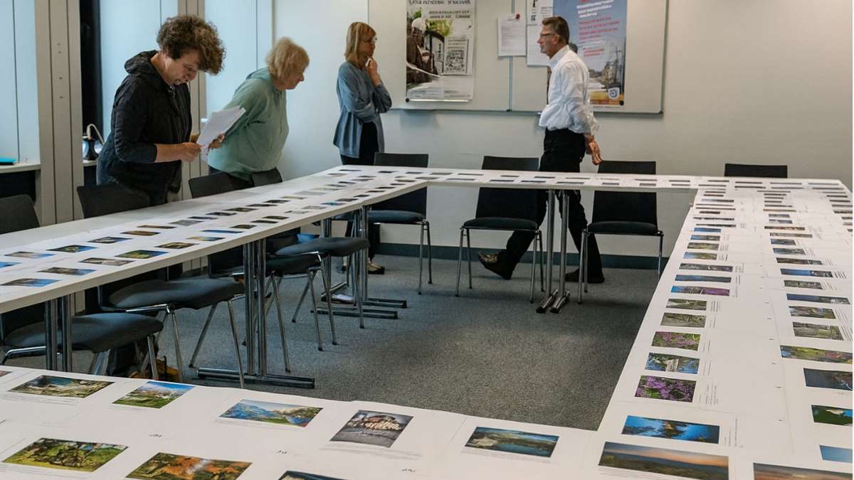 Mehrere Personen begutachten Fotos, die auf Tischen ausgebreitet sind. | Foto: Monika Pellkofer, Landkreis Bayreuth