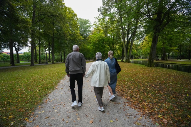 Ein älteres Paar läuft mit einer jüngeren Frau durch den Hofgarten. Foto: Stadt Bayreuth