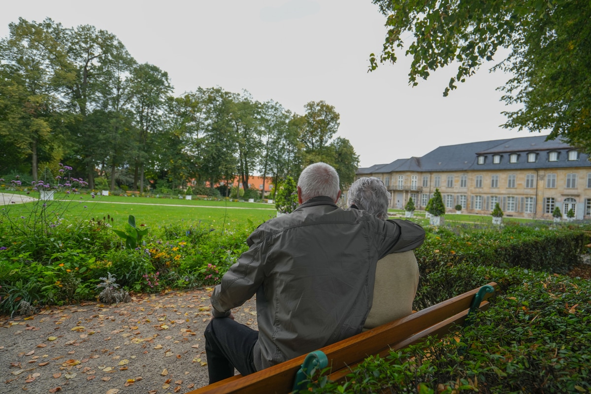 Ein älteres Paar sitzt auf einer Bank im Hofgarten Bayreuth. Foto: Stadt Bayreuth