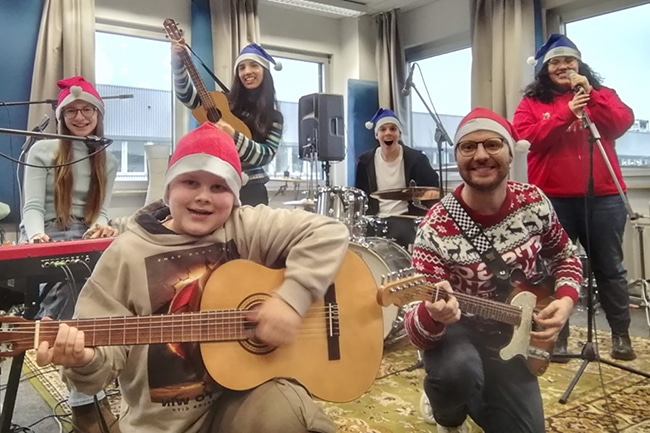Junge Musiker mit Nikolasmützen auf dem Kopf und Instrumenten in der Hand.