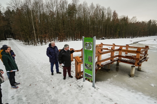 Robert Pfeifer erläutert im Beisein von Oberbürgermeister Thomas Ebersberger und Medienvertretern vor einer Infotafel die Rekultivierung der historischen Weiher im Studentenwald. Foto: Stadt Bayreuth