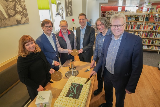 Eine Frau und fünf Männer schneiden eine Geburtstagstorte an. Foto: Stadt Bayreuth