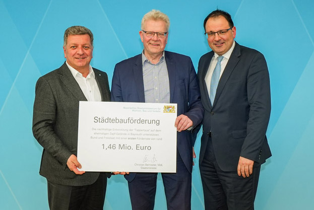 Drei Männer halten einen großen Förderbescheid in die Kamera. | Foto: Stadt Bayreuth