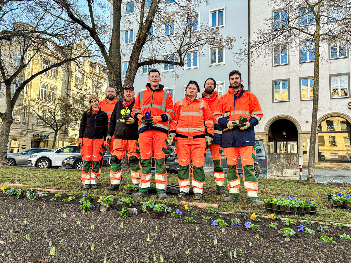 Gärtner des Stadtgartenamtes stehen auf dem Luitpoldplatz, wo sie gerade Blumen pflanzen. Foto: Stadt Bayreuth