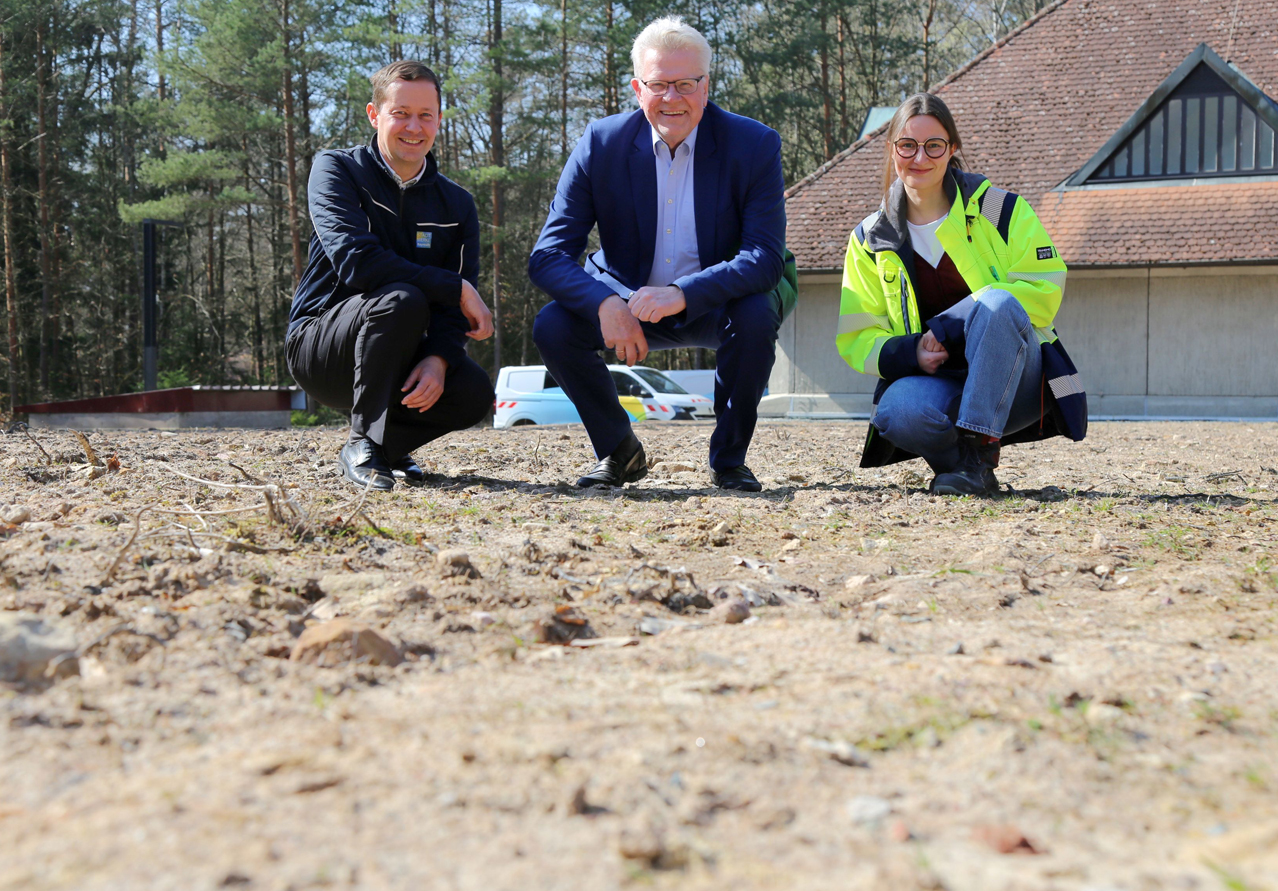 Zwei Männer und eine Frau knien auf einer Magerwiese. | Foto: Stadtwerke Bayreuth