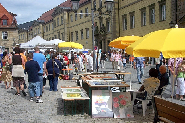 Menschen laufen an den Ständen des Künstlermarktes vorbei.