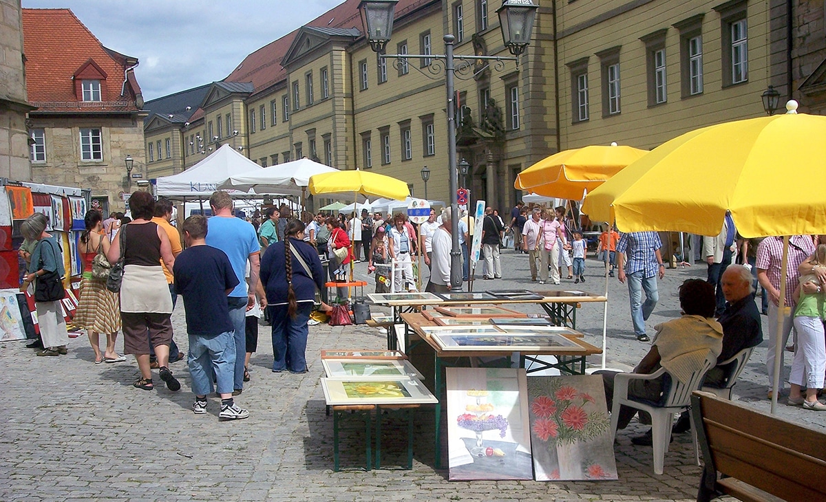 Menschen laufen an den Ständen des Künstlermarktes vorbei.