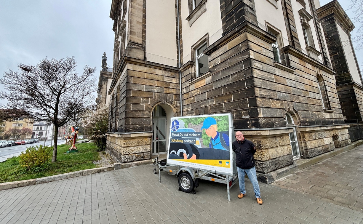 Ein Mann steht vor einem Plakat an einer Gebäudefront. | Foto: Stadt Bayreuth