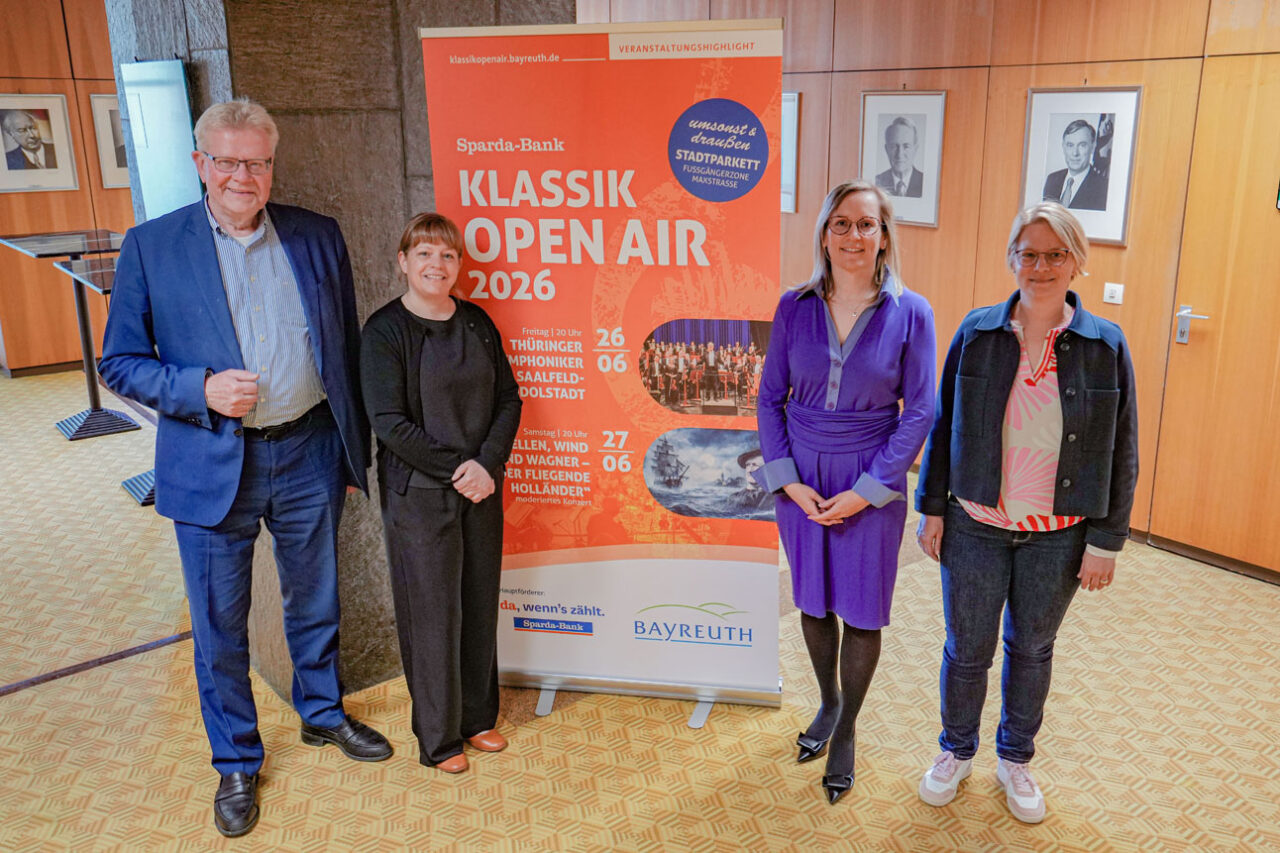 Vier Personen stehen vor einer Werbewand. | Foto: Stadt Bayreuth