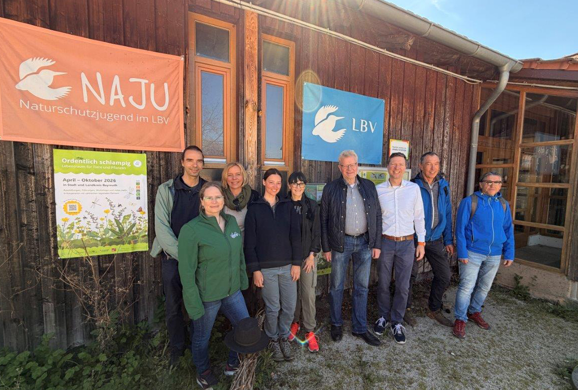 Mehrere Personen stehen vor einer Holzhütte mit Transparenten. | Foto: Region Bayreuth