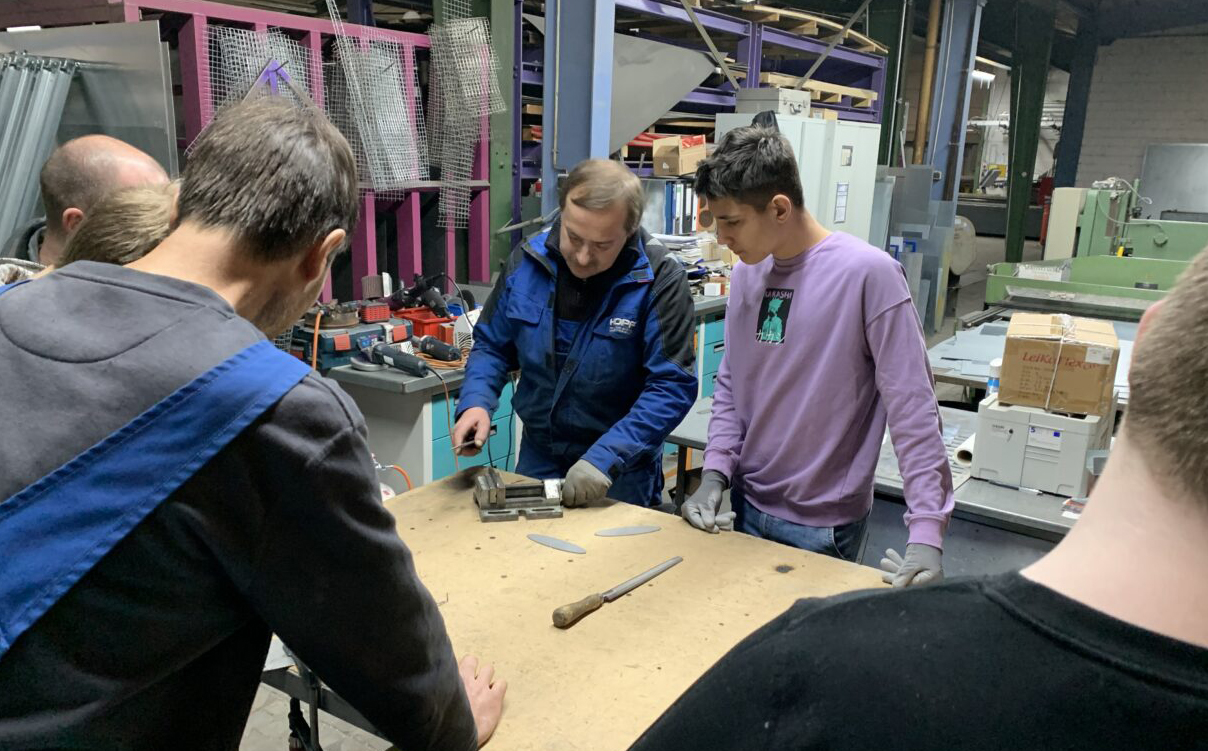 Mehrere Personen stehen um einen Montagetisch in einem Betrieb. | Foto: Stadt Bayreuth